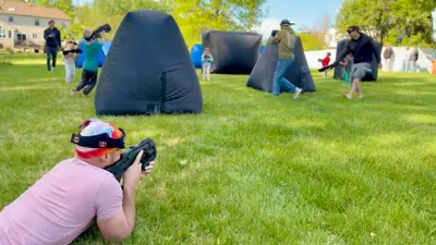 Full mobile laser tag arena with kids and parents playing together in a Glen Mills, PA backyard