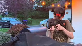 Teenager aiming a pro-grade laser tagger in a driveway at his backyard 14th birthday laser tag party