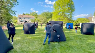 Group of boys and girls gearing up with laser taggers and headbands before a backyard birthday game in Glen Mills, PA