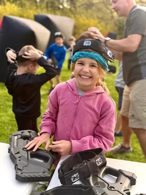 Young girl smiling as she gears up at a Philadelphia-area mobile laser tag birthday party for an 8 year old