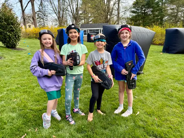 Four girls posing with their laser taggers at an 8 year old's mobile laser tag birthday party