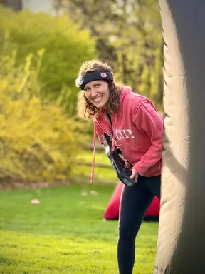 Adult player smiling and peeking around a bunker during a family-friendly kids' birthday party in Pennsylvania