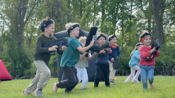 Group of kids charging across the yard at the start of a mobile laser tag battle in Glen Mills, PA