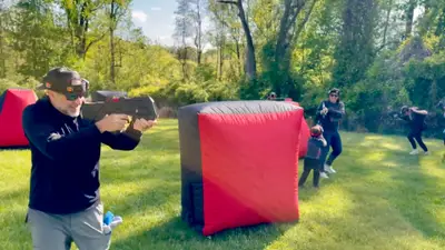 Dad firing a pro-grade laser tagger during a family-friendly backyard birthday party in Glen Mills, PA