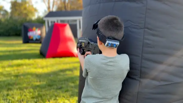 Children running with laser taggers during a backyard birthday party in West Chester, Pennsylvania